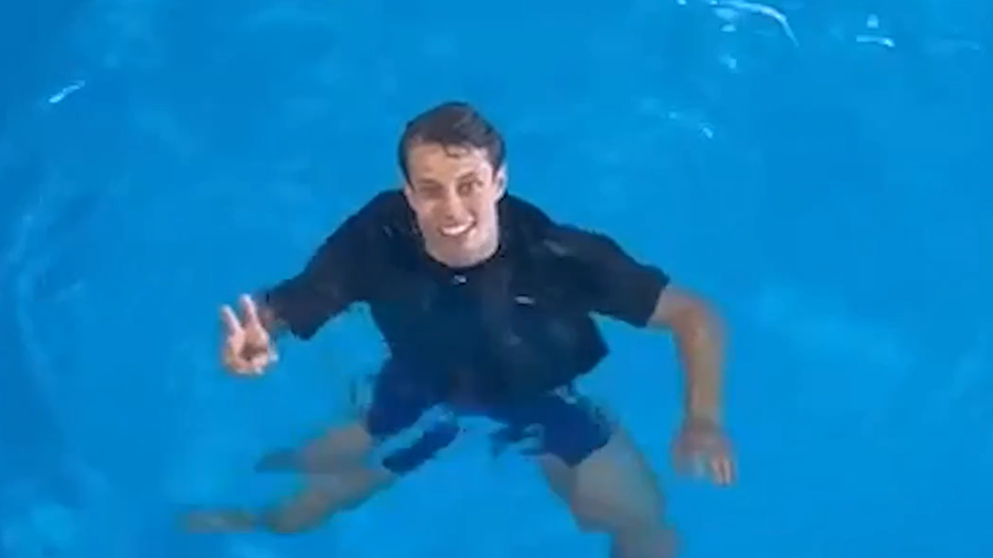 Jacob Ward floats in the RNLI's sea survival pool. He's looking up towards the camera and smiling. 