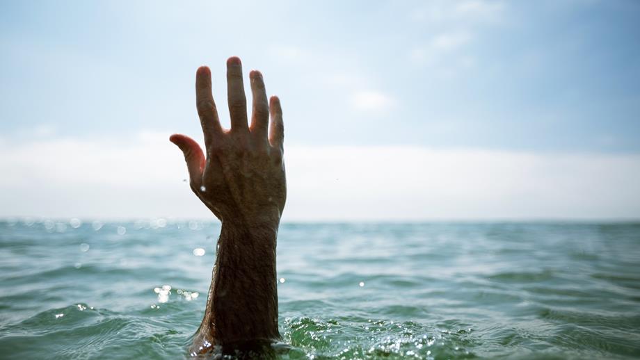 A hand is reaching up from the water