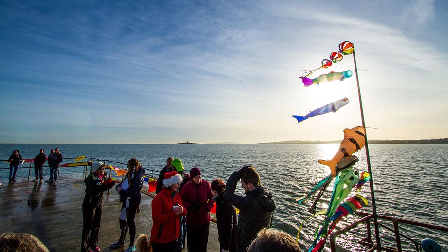 A group of open water swimmers gather by the sea. Sea swimming for beginners is best done as part of a group such as the Frosties in Skerries, Co Dublin