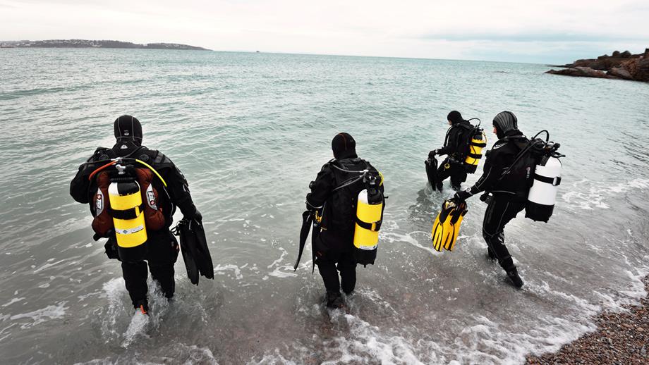 A group of divers walking into the sea 