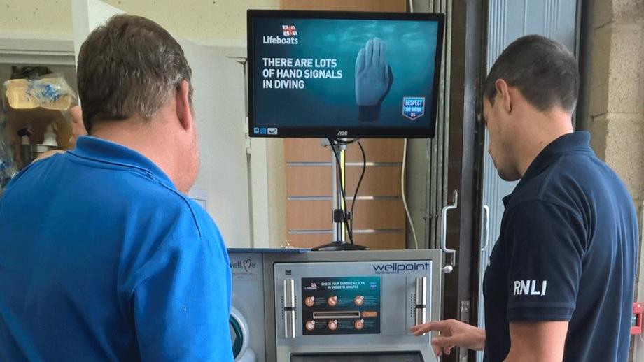 A man prepares to step on an RNLI health check kiosk 