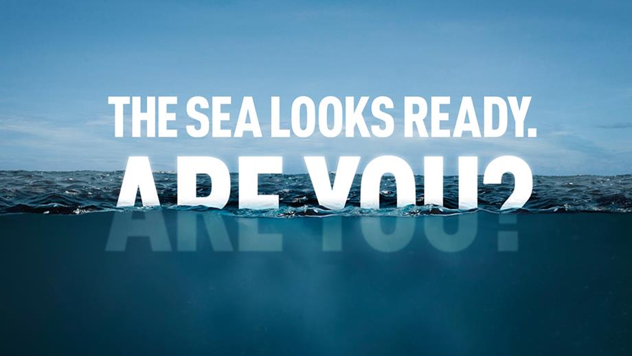 The words The Sea Looks Ready partially submerged in cold blue sea water