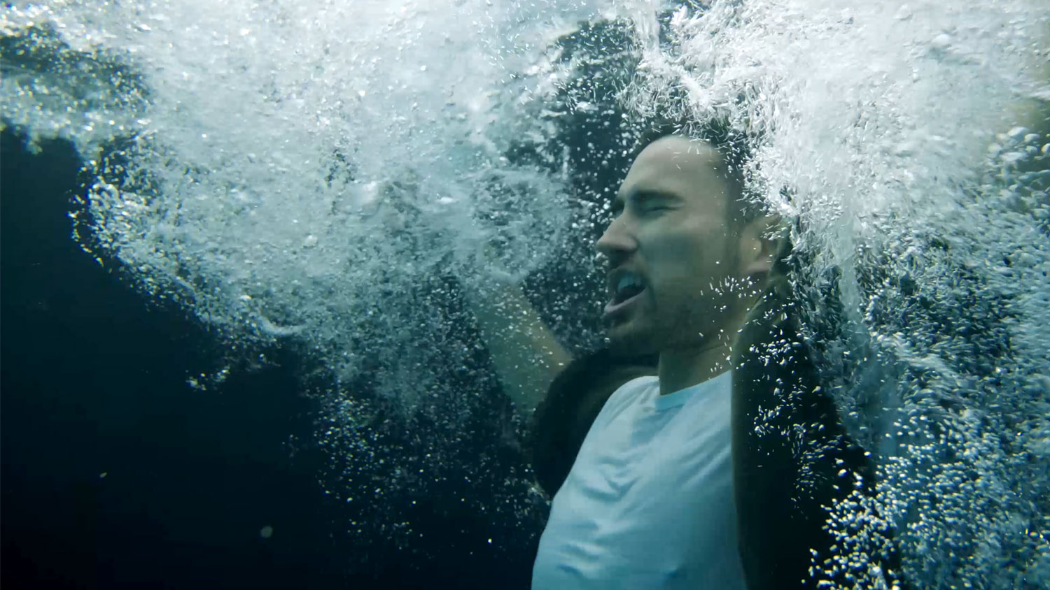A still from the RNLI's Float to Live film, showing a man who has fallen into the water.