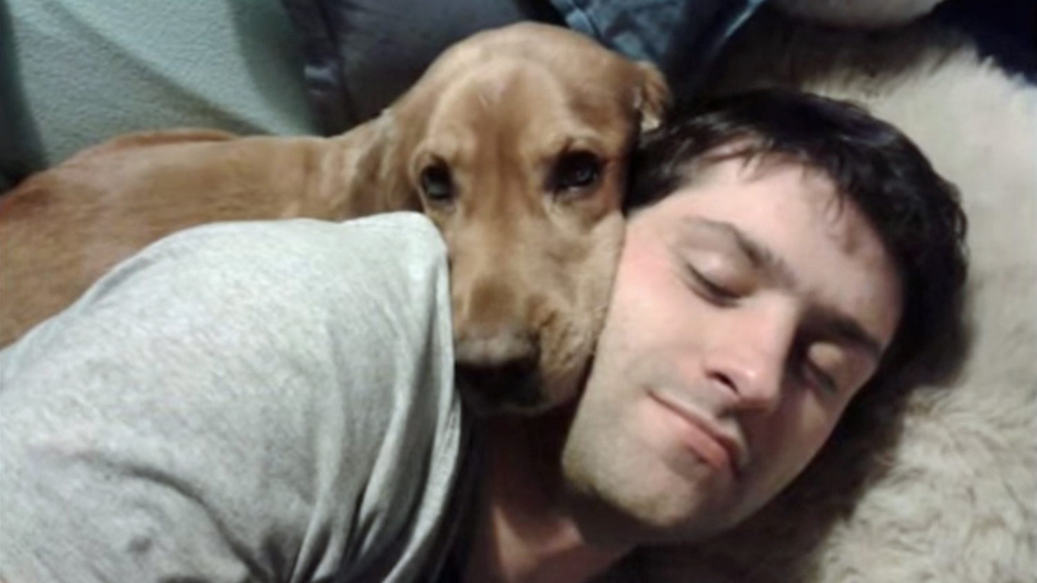 Alex snuggling with his dog