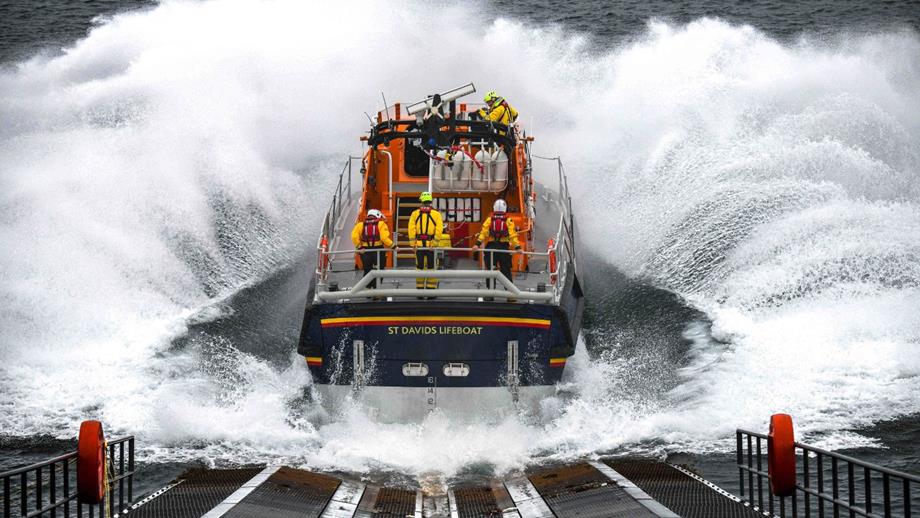 St Davids lifeboat station’s Tamar class all-weather lifeboat launches from the slipway into seas creating a huge splash as it enters the water