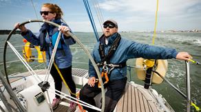 Two sailors helming a yacht
