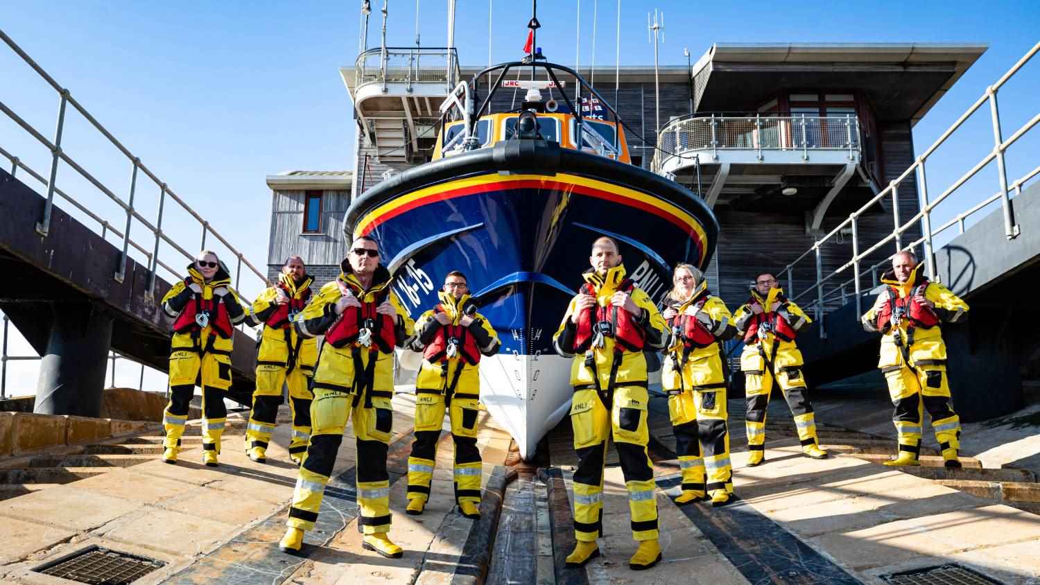 Group shot of Shoreham volunteer crew membes on the sliwpay in front of the Tamar class Enid Collett 16-15 at the lifeboat station.