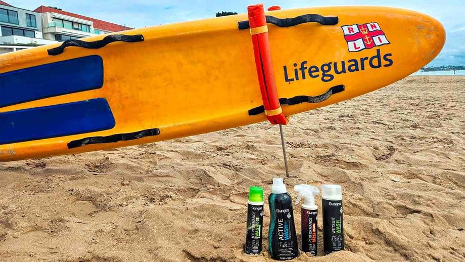 Grangers International products on a beach in front of an RNLI rescue board.