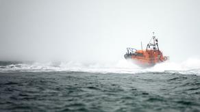 An RNLI Shannon class all-weather lifeboat powers away from us in rough seas