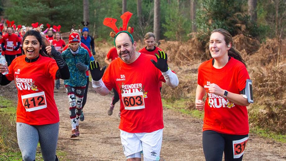People running in the woods during an RNLI Reindeer Run event