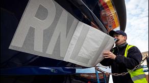 A decal with a serial number including the names of loved ones being applied to the hull of a Shannon class lifeboat.