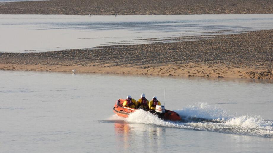 Image of Wells lifeboat on the water with two crew members on board