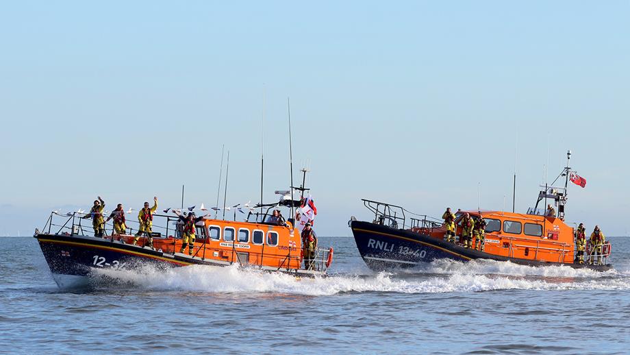 Aldeburgh's lifeboat is escorted by Eric's Legend on it's final launch from Aldeburgh beach to Lowestoft Lifeboat station. The crew on the Aldeburgh lifeboat deck are waving goodbye.