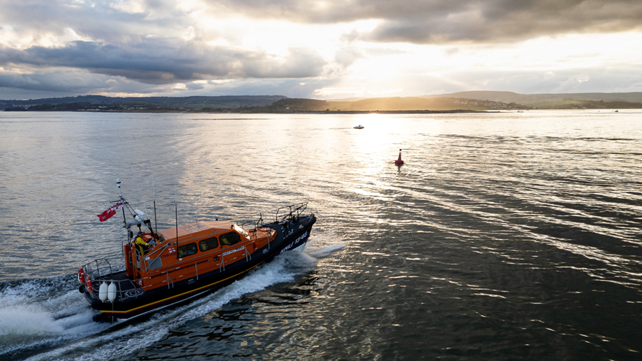 Aerial drone shots of launch and recovery exercise of RNLI Exmouth Shannon class lifeboat R and J Welburn 13-03 at sunset.