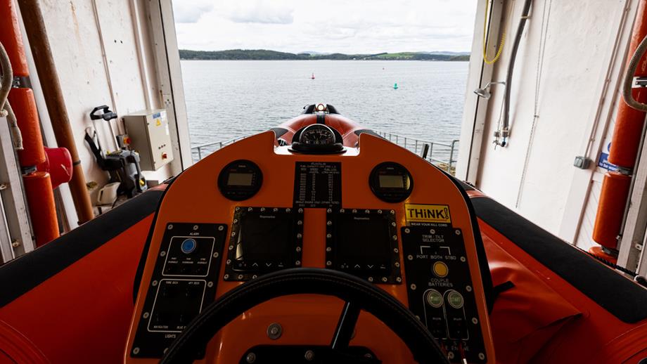 The bow of RNLI lifeboat Sheila Stenhouse inside Kirkcudbright lifeboat station. Sea and horizon in background