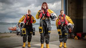 Three female crew members kitted up on their slipway