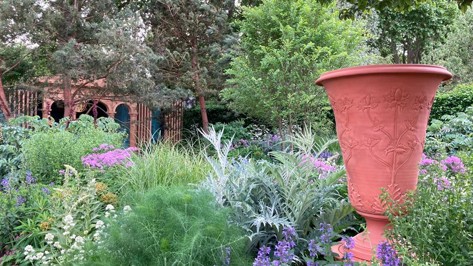 The RNLI’s garden at the RHS Chelsea Flower Show. A large urn is surrounded by purple and pink flowers.