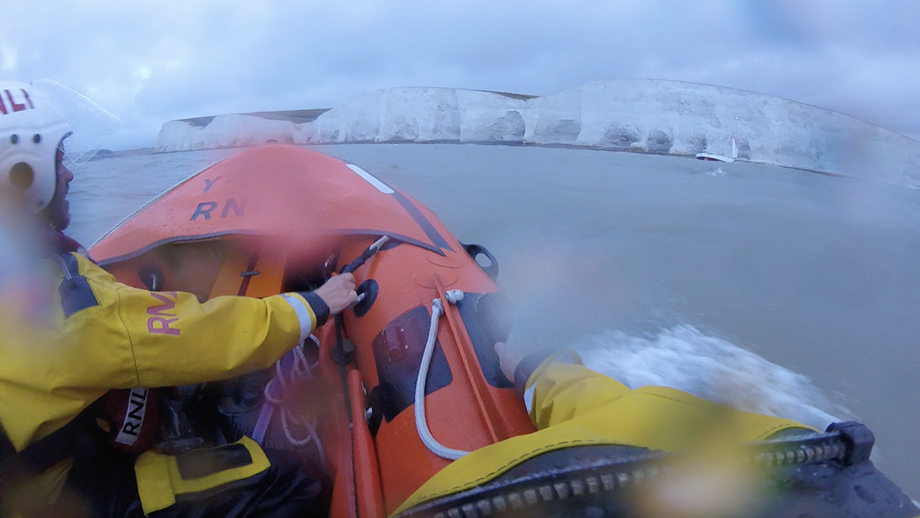 The crew at Newhaven use their Y-boat to reach a sailor in trouble