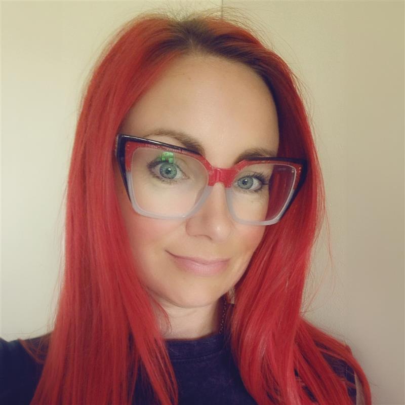 A portrait of rescuee Pamela Muirhead looking at the camera wearing glasses
