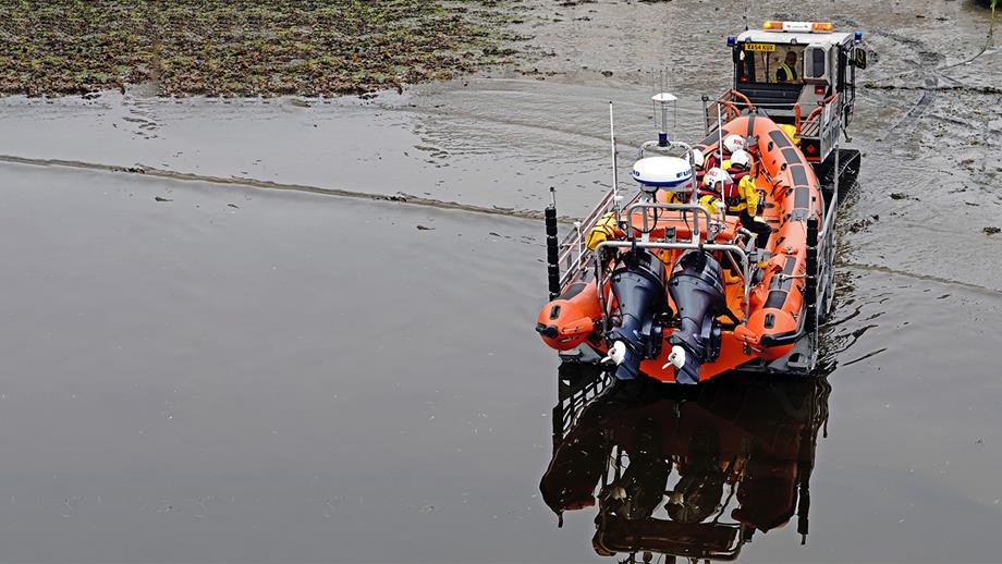 Stonehaven Lifeboat Station’s B class lifeboat being pulled out of the shallow water, and onto the shore, by the launch and recovery tractor.