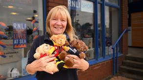 Shop volunteer Rosie holding teddy bears outside an RNLI shop