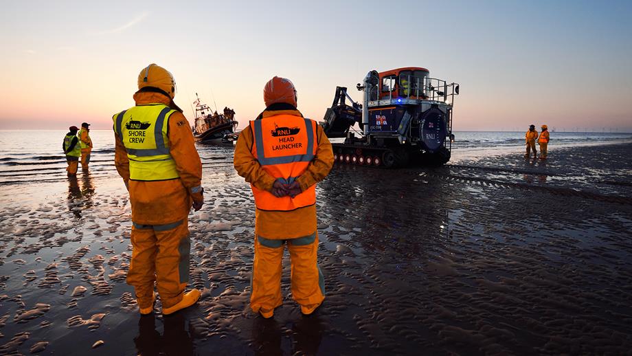 RNLI shore crew volunteers work together to retrieve their station lifeboat after a shout using a launch and recovery tractor.