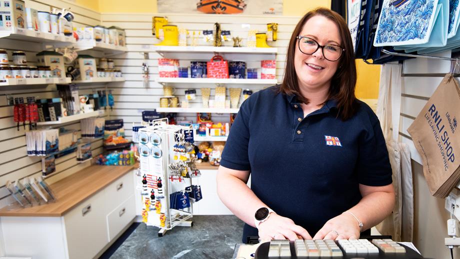 Volunteer Shop Manager Samantha Peters stood behind a till at Montrose RNLI Shop.