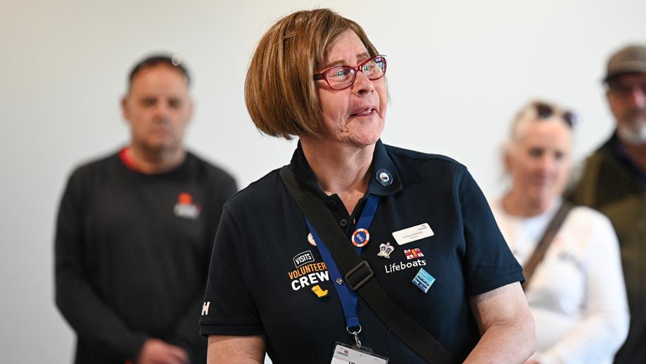 An RNLI visits volunteer talking to a member of the public.