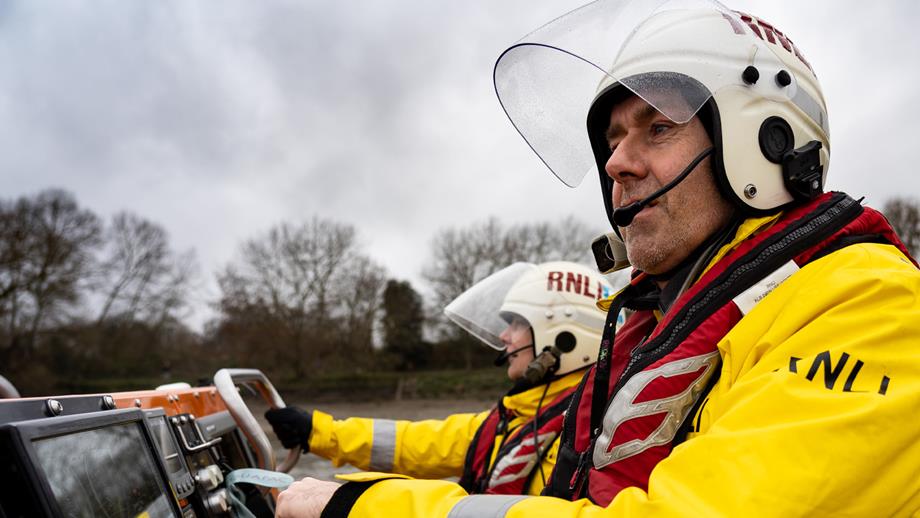 A close up of two crew members onboard the Chiswick E class lifeboat Brawn Challenge during a training exercise on the River Thames. 