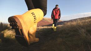 People walking wearing RNLI yellow wellies