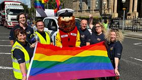 RNLI representatives, including Stormy Stan, holding a rainbow flag at Belfast Pride
