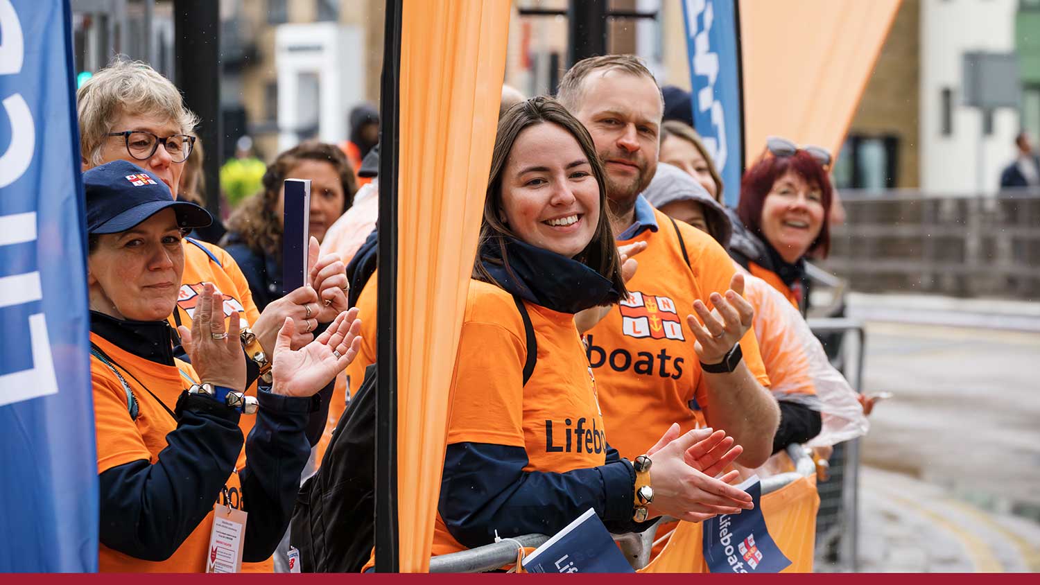 RNLI people wearing branded T shirts cheering at the side of the London Marathon