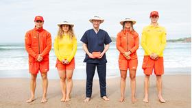 RNLI lifeguards standing on the beach and holding a Map My Mole kit