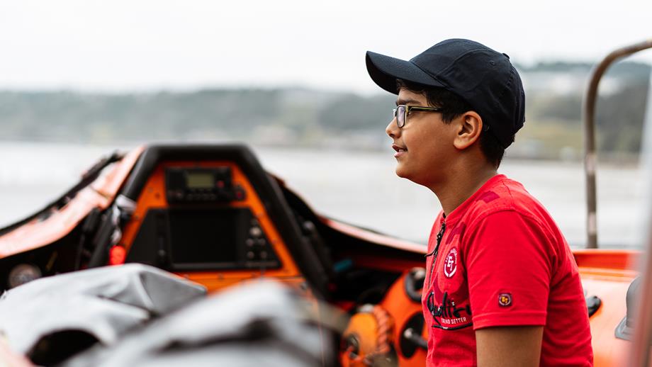 Ravi sits in a lifeboat and looks across the sea on a visit back to Scarborough to thank the lifeboat crew that rescued him