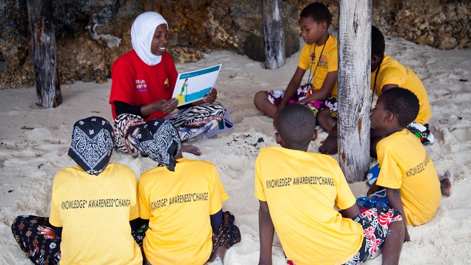 Children learning water safety messages on the beach in Zanzibar