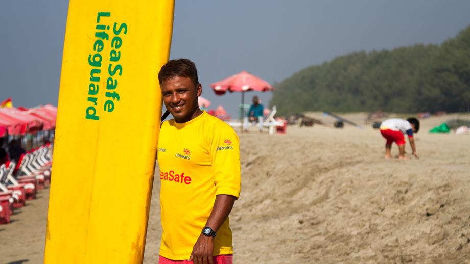 Lifeguard Alamgir with a rescue board he made from recycled materials
