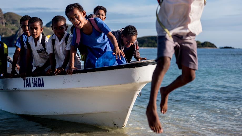 Children in Fiji return from school by boat