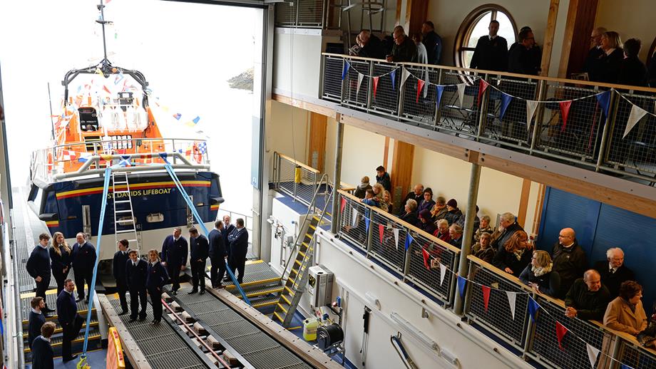 People are gathered inside the new boathouse and the Tamar class lifeboat is on the slipway.