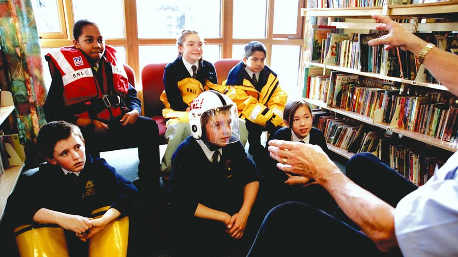 Young people learning about water safety from an RNLI education volunteer 