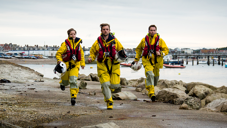 Swanage RNLI crew members running along the harbour
